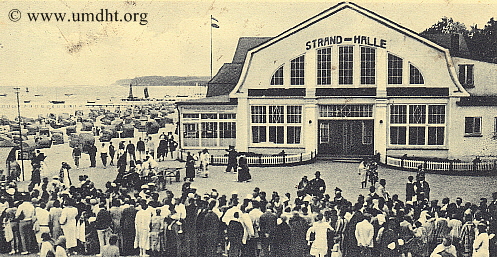 Die Strandhalle . W . Fick in Grömitz um das Jahr 1915 vom Brückenvorplatz aufgenommen mit auf die Einschiffung wartende Gäste. Die Strandhalle . W . Fick in Grömitz um das Jahr 1915 vom Brückenvorplatz aufgenommen mit auf die Einschiffung wartende Gäste.