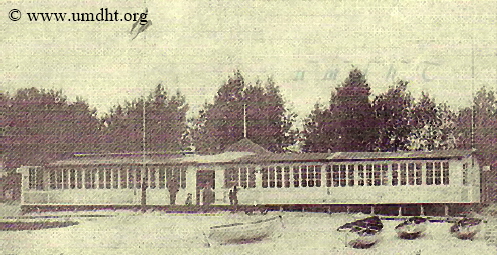 Vorbecks Strandhalle im Jahr 1906 mit integrierter Giftbude und Unterpfahlkonstruktion. Im Vordergrund sind diverse Ruderoote zu erkennen, die Vorbeck vermietete.